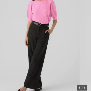 Rosa stickad tröja med puffärm från Vera Moda - Superfin rosa stickad tröja från Vera Moda med puffiga korta ärmar och rund hals. Tröjan är perfekt för sommaren och gör outfiten unik. Perfekt för dig som vill ha en färgklick i garderoben!