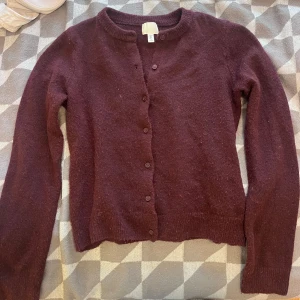 Vinröd kofta med knappar - Vinröd kofta från H&M med rund halsringning och knäppning framtill. Långärmad och mjuk, perfekt för lager-på-lager. Enkel och stilren design som funkar till många outfits.