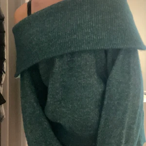 Grön offshoulder stickad tröja -  grön stickad tröja med bred offshoulder. Perfekt för dig som gillar oversized känsla och vill ha något snyggt och bekvämt till höst och vinter. Långa ärmar med mjukt o tjockt material.