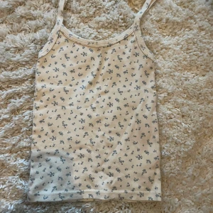 Blommig linnetopp från Brandy Melville - Supersött linne från Brandy Melville, endast testad på så det är i mycket bra skick. Perfekt nu till sommaren🍒🌺🩷