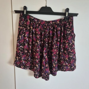 Blommig shortskjol från Bik Bok - Supersöt shortskjol från Bik Bok med blommigt mönster. Shortsen är luftiga och har en flowy passform som ger en avslappnad vibe och ser ut som en kjol. (Obs! Bilden med shortsen på har jag lånat från annan säljare då jag ej längre kan ha mina!)