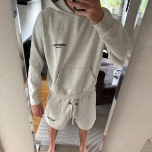 Ljusgrå Essentials Fear of God hoodie - Skriv för fler bilder! HELT NYA!Säljer en stilren ljusgrå hoodie från Essentials Fear of God. Tröjan har stor huva, magficka och svart logga tryckt både fram och bak. Skön passform och perfekt för chill dagar. Materialet är mjukt och känns riktigt nice mot huden.