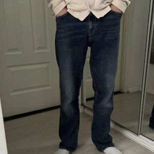 Mörkblå jeans från Replay - Säljer ett par mörkblå jeans från Replay med klassisk femficksdesign och raka ben. Jeansen har snygga slitningar och kontrastsömmar, tillverkade i bomull. Perfekta för dig som gillar en avslappnad och tidlös look. Modellen på jeansen är Thad. Nypris: ca 800kr. Mitt pris är inte hugget i sten, vid frågor skriv dm