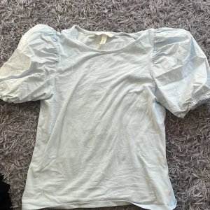 Ljusblå topp med puffärmar - Supersöt ljusblå topp från H&M, storlek s, har 2 smååå hål som man inte märker av så mycket🩵