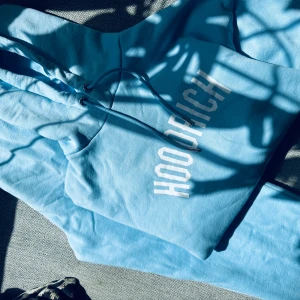 Ljusblå Hoodie och byxor från Hoodrich i xs - Superfint set från Hoodrich i ljusblått i storlek xs. På byxorna saknas de två silverplupparna som sitter längst ut på snöret men det är inget som stör då de hänger innanför byxlinningen.  Priset är för hela setet.