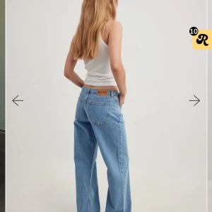 Ljusblå wide jeans från NA-KD - Säljer ett par ljusblå jeans från NA-KD med klassisk femficksdesign och raka, vida ben. Jeansen har normal midja och är tillverkade i jeansmaterial av bomull. Perfekta för en avslappnad och trendig look.