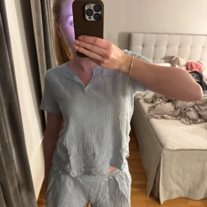 Blå pyjamas från Kappahl - En söt pyjamas i stolek S från Kappahl. Pyjamasen består av en topp, med ett litet v i halsen. Den består även av ett par luftiga och sköna shorts med fickor. Pyjamasen är i mycket bra skick då den knappt är använd. Hör gärna av dig vid frågor💗