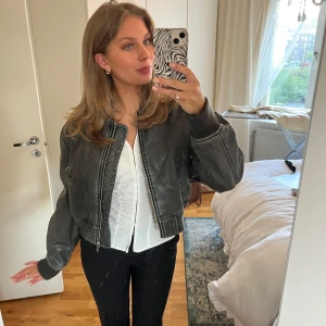 Svart skinn bomberjacka med dragkedja - Säljer en svart bomberjacka i skinn från Zara.