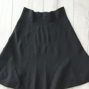 Svart kjol från ONLY i stickat material - Enkel och snygg svart kjol från ONLY i stickat material. Kjolen har en lätt utställd form och är perfekt för dig som gillar en klassisk look. Passar till allt och är superenkel att styla med både sneakers och boots.