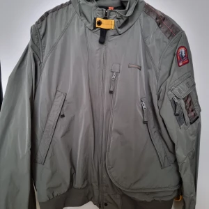 Parajumpers Fire bomb jacka - Olivgrön jacka från Parajumpers med flera fickor framtill, en patch på vänster ärm och en gul detalj vid kragen. Jackan har dragkedja och tryckknappar. Nypris 8400kr.