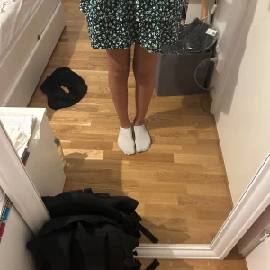 Grön blommig kjol från Zara - Supersöt grön kortkjol från Zara med vitt blommönster. Kjolen har en flowy passform och resår i midjan för extra komfort. Perfekt för vår och sommar när du vill ha en chill och snygg look. Den passar mig som har st 170 priset går alltid att duskertas 