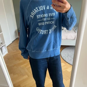 Blå sweatshirt från Zadig & Voltaire - Blå sweatshirt från Zadig & Voltaire med vit textprint på bröstet. Tröjan har rund halsringning, raglanärmar och avslappnad passform. Tillverkad i mjuk bomull.