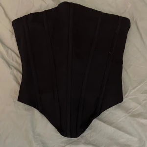 Svart Jacquie korsett Babyboo - Aldrig använd, finns lapp kvar. Från babybooFashion. Har en kedja på sidan och dessutom snöre som man ser på bild. Köpt för 63€ men är just nu på rea för 31€, dock är den helt slutsåld.