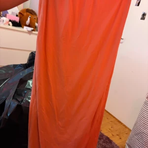 Orange långkjol från SHEIN XS - En enkel och snygg orange långkjol från SHEIN i storlek XS. Kjolen är rak i modellen och har resår i midjan. Tillverkad i mjuk polyester med lite stretch för en bekväm passform. Perfekt för dig som gillar färg och vill sticka ut.