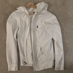 Polo Ralph lauren zip hoodie - Säljer en Ralph lauren vit zip hoodie med några små fläckar som kan nog försvinna en del i tvätten.