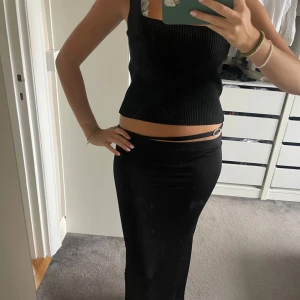 Svart långkjol med midjedetalj - Säljer en svart långkjol med tight passform och snygg detalj i midjan med en smal rem och metallring. Från avora Bianca’s märke! NYPRIS: ca 1500kr!!!