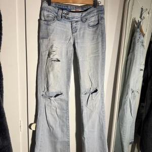 Ljusblå bootcut jeans från Only vintage - Säljer ett par ljusblå bootcut jeans från Only med slitna detaljer och hål vid knäna. Längd 32!