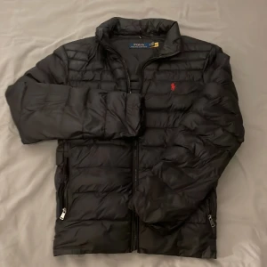 Ralph Lauren jacka  - Säljer denna svarta vårjacka från Ralph Lauren. Skick:7/10 pga en dragkedja som inte går att dra upp på vänstra fickan. Nypris är runt 3500kr, mitt pris ligger på 999kr. Storleken är S och passar mig bra som är 181 cm. Hör gärna av er om ni har några frågor.