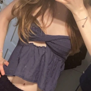 Mörkblå croppad tubtopp med twist - Supersöt mörkblå tubtopp med twistad detalj framtill och liten cut-out under bysten. Toppen är croppad och har en luftig, lätt utsvängd passform. Perfekt för varma dagar och ger en chill vibe till din outfit.