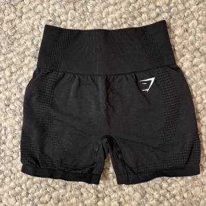 Svarta Gymshark träningsshorts  - Svarta seamless shorts från Gymshark med hög midja. Stretchigt material som sitter tight och bekvämt, perfekt för gym eller annan träning. Gymshark-logga framtill, sparsamt använda!🖤Har klippt bort lappen men tror det är XS.