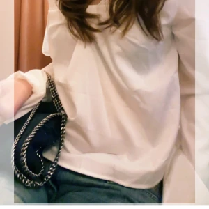 Vit blus med knyt framtill - Säljer en söt och luftig vit blus med knyt framtill och långa, vida ärmar. Blusen har en lätt transparent känsla och är perfekt att styla med jeans eller kjol. Den har en feminin v-ringning och ett flowy fall.