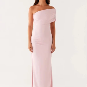 Ljusrosa långklänning från Peppermayo - Säljer en elegant ljusrosa långklänning från Peppermayo, modell Socialite Maxi Dress. Klänningen har oneshoulder-design och figurnära passform som ger en snygg siluett. Materialet är mjukt och följsamt, perfekt för att sticka ut med en stilren look. Säljes pga för liten, köpt på Vinted och inte använd av den förra ägaren oxå