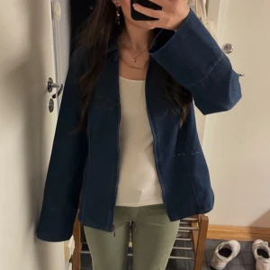 Mörkblå jeansjacka från JDY - Säljer en stilren mörkblå jeansjacka från JDY i storlek S. Jackan har dragkedja framtill, klassisk krage och raka ärmar. Jackan har en liten repa framtill, men det är inget som syns jättemycket eller stör. Passformen är normal 💗