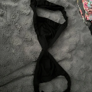 Svart bikiniöverdel med spänne - Snygg svart bikiniöverdel med breda axelband och praktiskt spänne framtill. Triangelformade kupor och stilren design som passar perfekt till stranden. Materialet känns mjukt och följsamt mot huden, och färgen är helsvart för en klassisk look. Vid frågor hör av dig!