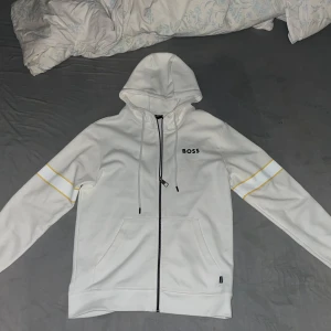 Vit hoodie från BOSS med gula detaljer - Hej ja säljer min tracksuit boss har använt typ 3 gånger bara storlek är L men passar också M