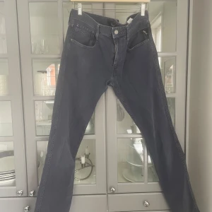 Blåa Replay Anbass Jeans - Snygga blåa jeans från Replay, modell Anbass. De har en klassisk femficksdesign och en knappgylf. Perfekta för en stilren look.