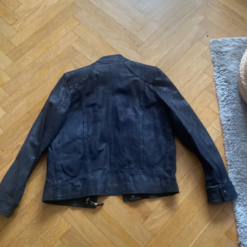 Snygg svart skinnjacka från Zara Man med dragkedja och knappar. Jackan har en stilren design med quiltade detaljer på axlarna och två praktiska fickor med dragkedja framtill. Storlek M men passar S. Pris kan diskuteras.. Takit.