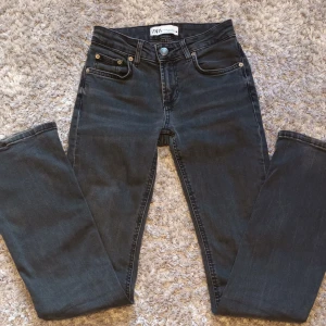 Svarta jeans från Zara - Snygga svarta Utsvängda  jeans från Zara.  Storlek 32. Lite uppskavda på ena benets kant annars inga effekter. Super sköna i materialet.