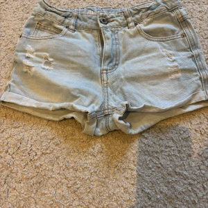 Ljusa jeansshorts med slitningar - Snygga ljusa jeansshorts med slitningar. De är storlek 152 men passar en xss-xs.