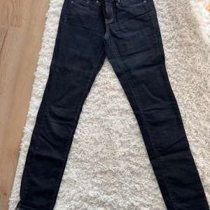 Mörkblå jeans med gula sömmar från ONLY - Snygga mörkblå jeans från ONLY Limitless Denim. De har en klassisk femficksdesign och är tillverkade i ett stretchigt material för en bekväm passform. Riktigt snygga med sina gula sömmar. Perfekta för en stilren look. Stl 26/34