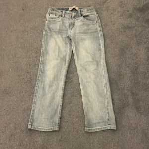 Levi's 551Z ljusblå jeans - Snygga ljusblå Levi's 551Z jeans med en rak passform. Klassisk design med fem fickor och knappgylf. Perfekta för en avslappnad stil. Storleken på byxorna är 140-146 i cm