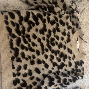 Leopardmönstrad tröja från H&M - Säljer en snygg leopardmönstrad tröja från H&M i storlek M. Tröjan har långa ärmar och en bekväm passform med ribbade muddar vid ärmslut och nederkant. Perfekt för att ge din outfit en trendig touch 🐆