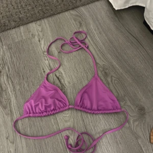 Lila bikiniöverdel - Snygg lila bikiniöverdel med knytband. Perfekt för sommardagar vid stranden eller poolen. Triangelformad design som ger en klassisk look.