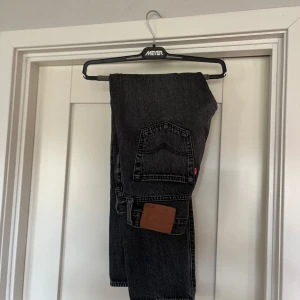  Levis 501 jeans - Säljer ett par klassiska svarta Levis 501 jeans. De har en rak passform. Perfekta för en stilren look. Jeansens ikoniska design gör dem tidlösa och lätta att matcha med olika outfits. Storlek W28 L30.