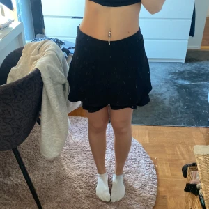 Svart kortkjol med dragkedja - Snygg svart kortkjol med dragkedja i sidan. Perfekt för en stilren look. Kjolen har en lätt utsvängd form som ger en fin siluett.