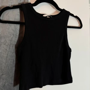 Linne i ribbat material - !LÄS BIO INNAN KÖP! Säljer detta linne i ribbat material, ärmlös och har en croppad passform. Passar perfekt till sommaren eller som en fest topp! För fler bilder är det bara att skriva!