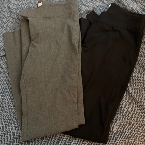 Grå och svarta low waist kostymbyxor - Snygga kostymbyxor i grått och svart. De har en klassisk design med låg midja och raka ben. Perfekta för en stilren look. 250 för bägge!