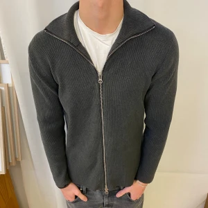 Mörkgrå stickad kofta från Ljung - Snygg mörkgrå stickad kofta från Ljung by Marcus Larsson. Koftan har hel dragkedja, ribbad struktur och hög krage. Helt nytt skick och tvär skön på sommar kvällar , skriv för frågor eller likande 🤗