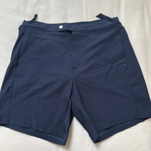 Mörkblå badshorts från La Perla NYA! - Snygga mörkblå badshorts från La Perla med justerbara spännen i midjan och diskret bakficka med dragkedja. Klassisk rak passform och meshfoder på insidan för extra komfort. Perfekta för stranden eller poolen. Helt nya och storlek M. Ny pris ca 1600kr 