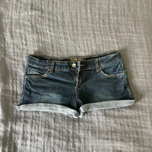 Mörkblå lågmidjade jeansshorts  - Snygga mörkblåa och lågmidjade jeansshorts från Sublevel. De sitter jättebekvämt och är i storlek M. Perfekta för sommaren! 