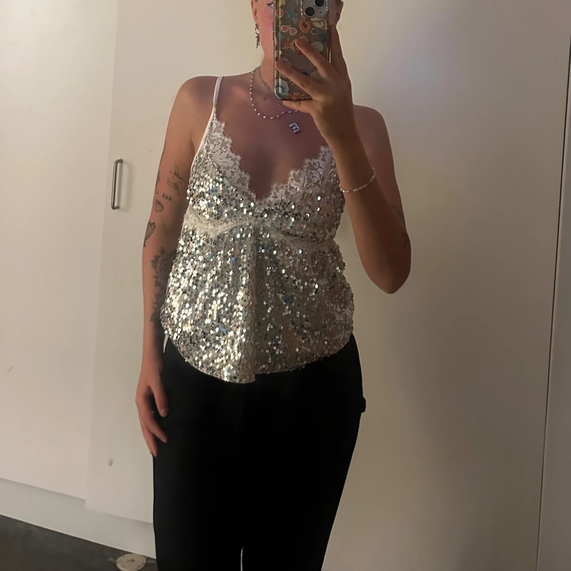 Glittrig silvertopp med spetsdetaljer