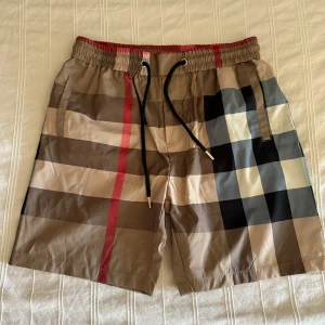 Burberry-rutiga shorts med snörning - Shortsen är XL men passar perfekt för dig som har M. Längden kommer precis överknäna. 