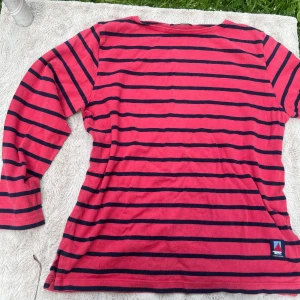 Randig långärmad tröja Ravaldi - Snygg långärmad tröja från Ravaldi by Ann Wineus i röd och marinblå randigt mönster. Tröjan har klassisk rak passform och är tillverkad i mjuk bomull. Perfekt för dig som gillar en avslappnad och stilren look med marint tema.