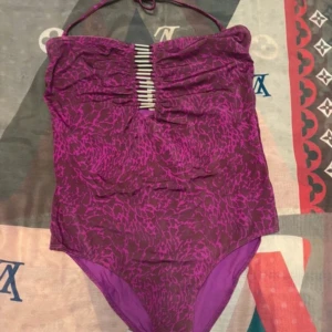 baddräkt - Oanvänd baddräkt från H&M – hygienplasten sitter kvar  Stilren och färgstark baddräkt i lila mönster, köpt från H&M. Aldrig använd – hygienplasten sitter fortfarande kvar. Prislappen är borttagen, men den är helt ny och i perfekt skick.