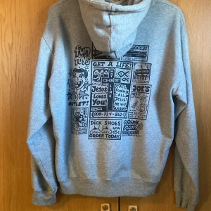 Grå hoodie med tryck och huva - Snygg grå hoodie från Polar Skate Co. med stor svartvit unik print både fram och bak. Tröjan har huva med snörning och en klassisk känguruficka.  Priset är inte hugget i sten!