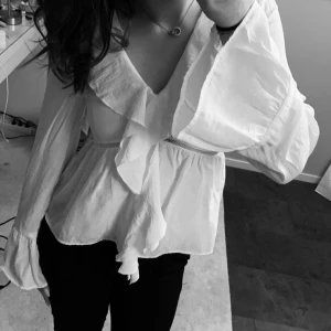 Vit blus från kappahl  - Vit blus med volang från kappahl  Superfin vit blus med omlott-look, volangdetaljer och långa ärmar. Snygg spetsdetalj vid midjan!💕 säljer pågrund av att den är för liten, använd 2ggr så är i väldigt bra skick! Skriv om ni har frågor eller undrar något✨